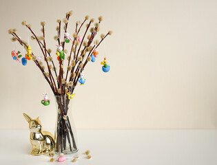 Pussy willow Easter tree with colorful decorations and a golden rabbit figurine