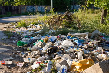 Large pile of litter and plastic waste polluting nature in urban area