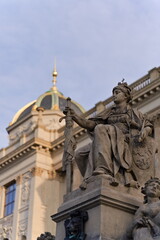 monumentalna rzeźba kobiety z mieczem na tle pałacu
