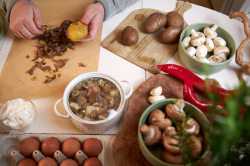 man peeling boiled potatoes, top view
