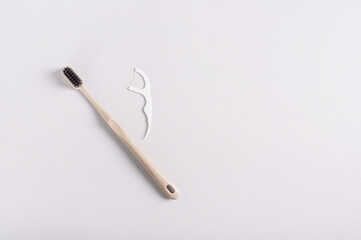 Toothbrush and disposable dental floss alternative for brushing teeth on gray background top view