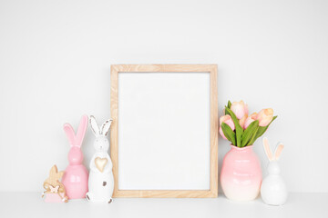 Modern Easter home decor shelf scene. Mock up portrait wood frame with Easter bunnies and tulip...