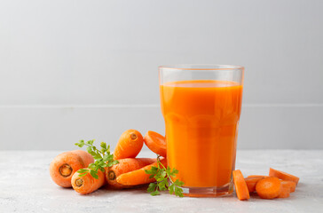 Carrot juice in a glass and fresh carrots
