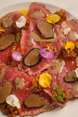 meat carpaccio with sliced truffle and flowers