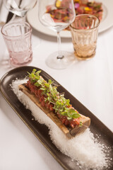meat tartare with salad over open bone