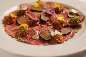 meat carpaccio with sliced truffle and flowers
