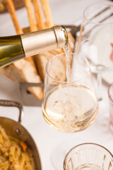 waiter pours white wine at restaurant