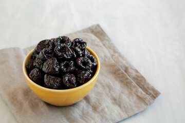 Raw Dried Plum Prunes in a Bowl, side view.