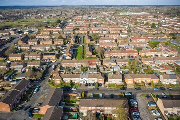 Obraz premium An aerial photo shows a dense suburban neighborhood of closely-packed, brick single-family homes with pitched roofs and small, well-kept yards.