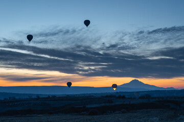 Aerial view of hot air balloon taking off at twilight in Cappadocia , Turkey