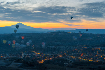 Aerial view of many hot air balloon taking off at twilight in Cappadocia , Turkey