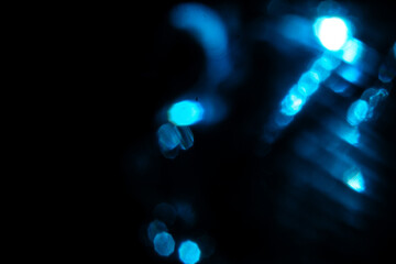 Blue lights bokeh on a black background. Abstract lights.