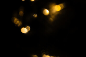 Golden lights bokeh on a black background. Abstract lights.