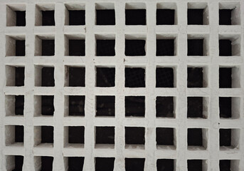minimalist and geometric view of white square perforated wall