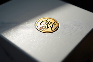 A close-up of a beautifully crafted badge reading made in usa, featuring a shiny gold finish on a sleek silver surface, capturing a sense of quality and craftsmanship