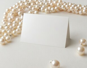Elegant blank card surrounded by lustrous pearl jewelry.