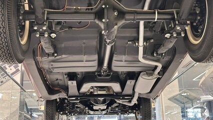 A car's undercarriage is shown in a museum.