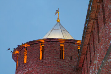 A brick tower with a gold top and a light shining on it. Sights of the Nizhny Novgorod Kremlin