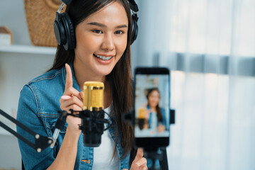 Host channel Asian influencer talking in broadcast wearing headsets on social media live on...