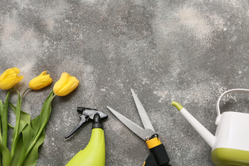 Gardening tools with tulip flowers on grey background. Top view