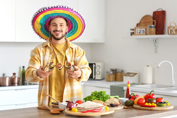 Young Mexican man preparing tasty tacos in kitchen