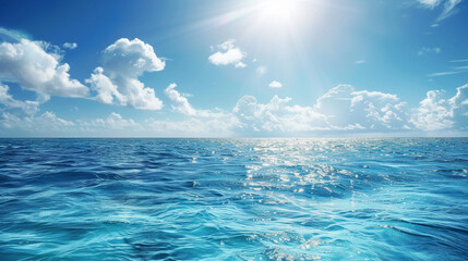 Obraz premium A vast, peaceful ocean view with sunlight shimmering on the water and scattered clouds above