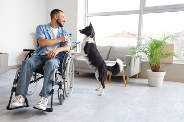Young man in wheelchair and with dog at home