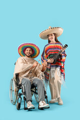 Young Mexican man in wheelchair and with wife playing music on blue background