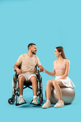 Young sporty man in wheelchair and with his wife on blue background