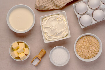 Food photography of raw ingredients of New York cheesecake, cream, soft cheese, sugar, butter, shortbread crumbs, vanilla