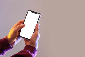 Man holding blank mobile phone on grey background