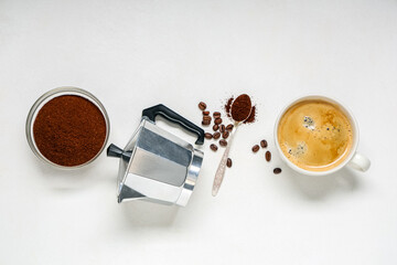 Cup of coffee with powder, beans and geyser coffee maker on white background