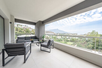 a balcony terrace with garden furniture overlooking the town of Marbella