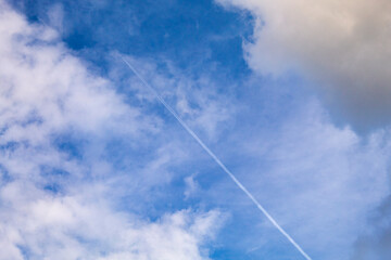 Path Through Turbulence: Airplane Contrail Dividing Dark and Light Clouds