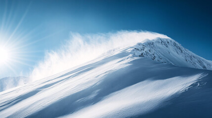 A towering snow-covered mountain peak glows under the bright sun with fresh powder and windblown snow swirling against a deep blue sky