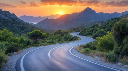 A winding road through the mountains at beautiful sunset