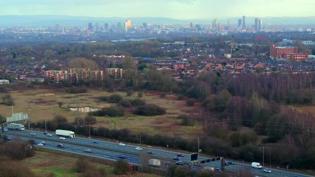 Aerial video of Manchester M60 outer ring road near Swinton area with Manchester skyline on the Horizon. 