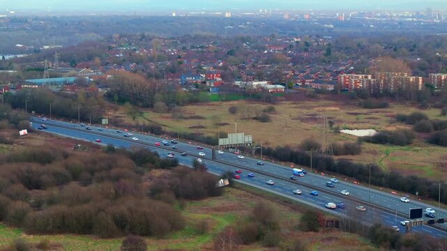 Aerial video of Manchester M60 outer ring road near Swinton area with Manchester skyline on the Horizon. 