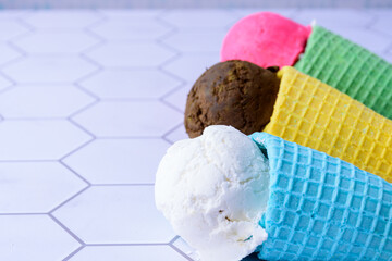 Three colorful cones with colorful ice cream scoops.