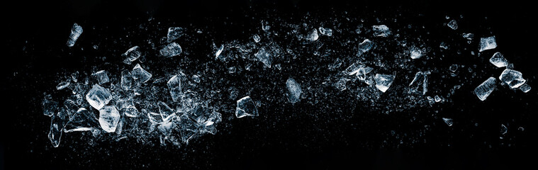 Ice cubes, crushed on a black background. wide format.