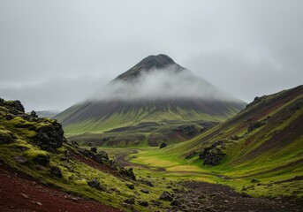 A wide-angle landscape of Iceland’s foggy mountain range under a moody sky.