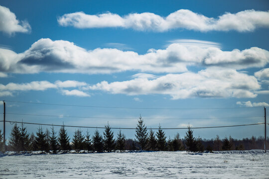 Winter Landscape with Power Lines and Rolling Clouds