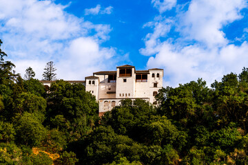 Fototapeta premium White Generalife of Alhambra from Granada’s Hillside: A Moorish Garden Retreat Overlooking Centuries of Andalusian Splendor and Enduring Serenity
