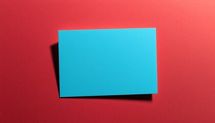 Fototapeta premium Plain sky blue business card on a solid red background.