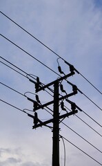 electric poles towering in the sky and the sky is clear with white clouds