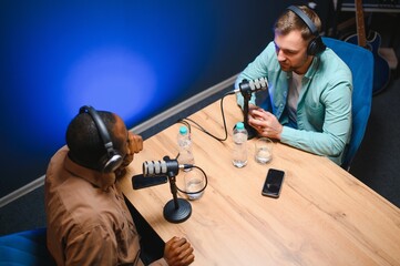 Podcast presenter having live discussion with man, streaming it for audience on internet...