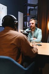 Man recording podcast using high tech microphones to interview guest, ensuring flawless video and...