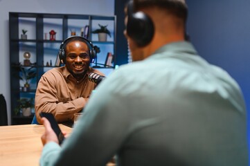 Man recording podcast using high tech microphones to interview guest, ensuring flawless video and...
