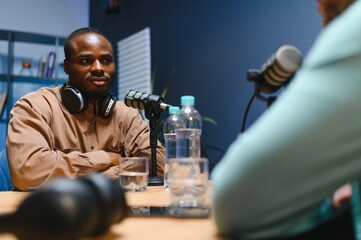 Man recording podcast using high tech microphones to interview guest, ensuring flawless video and...