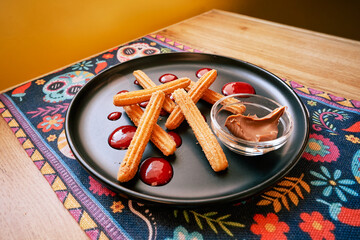 Crispy cinnamon churros with chocolate and raspberry sauce